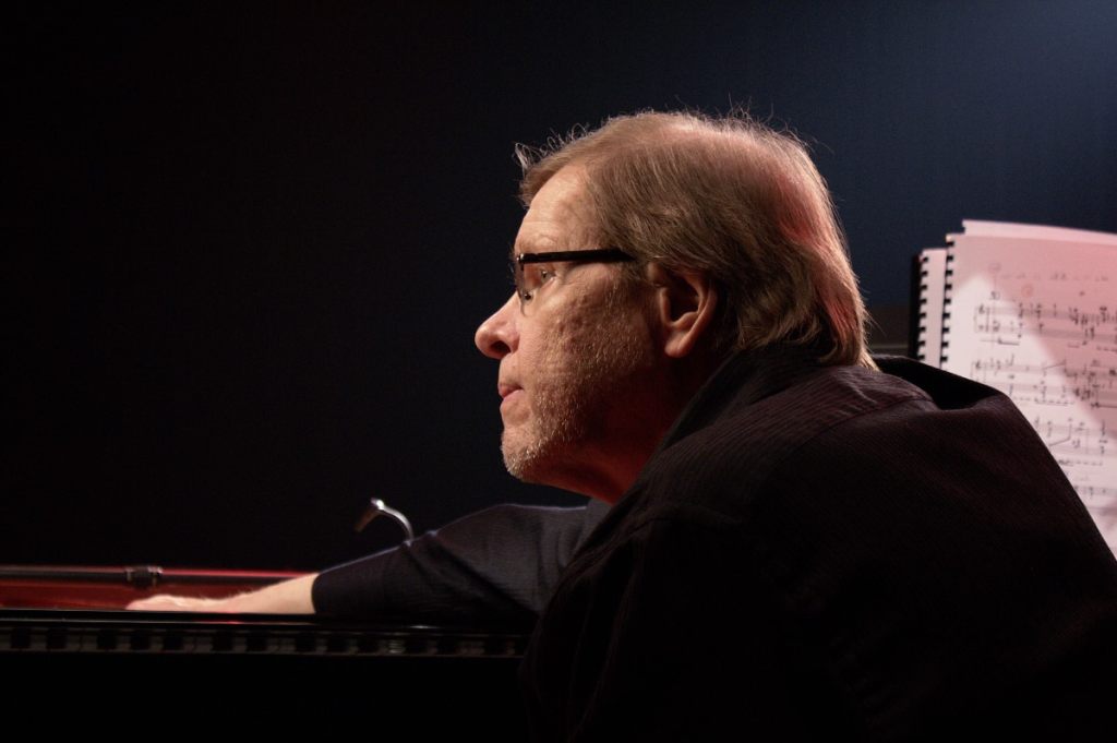 Man performing inside grand piano